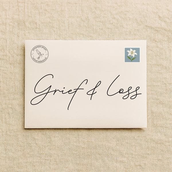 Christian grief-support letter subscription packaging with cream envelope on linen background